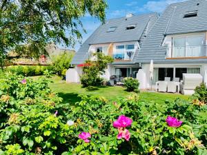 una casa con flores rosas en el patio en Haus Stübbe beim Dorfteich, en Wenningstedt