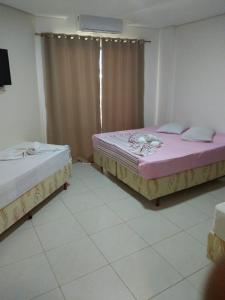 Łóżko lub łóżka w pokoju w obiekcie Ágape Hotel De Aparecida