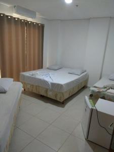 a room with two beds and a window in it at Ágape Hotel De Aparecida in Aparecida