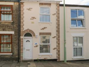a house with a white door and windows at Gull's Nest in Lowestoft