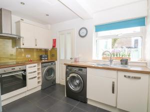 eine Küche mit einer Waschmaschine und einem Waschbecken in der Unterkunft Gull's Nest in Lowestoft