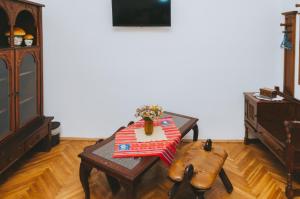 Una habitación con una mesa con un jarrón de flores. en Casa Vinco Vici, en Turda