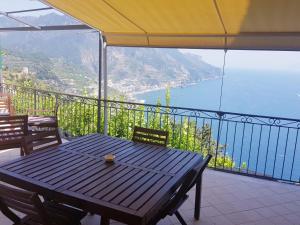 a table on a balcony with a view of the ocean at Le Esperidi House in Ravello