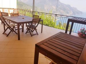 una mesa y sillas en un balcón con vistas al océano en Le Esperidi House, en Ravello