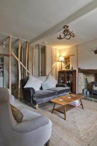 a living room with a couch and a coffee table at Jasmine Cottage, Upper Slaughter, Cotswolds in Cheltenham
