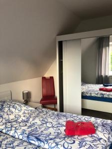 um quarto com uma cama e uma cadeira vermelha em Haus Trossenstek V em Büsum