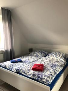 uma cama com duas almofadas vermelhas em cima em Haus Trossenstek V em Büsum
