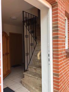 uma porta aberta para uma escada com um portão de ferro forjado em Haus Trossenstek V em Büsum