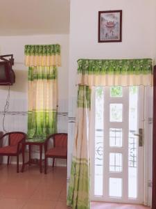 una habitación con cortinas, una mesa y una puerta en KHÁCH SẠN KIM PHỤNG NGÂN, en Bình Thủy
