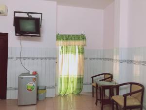 a room with a television and a table and chairs at KHÁCH SẠN KIM PHỤNG NGÂN in Bình Thủy