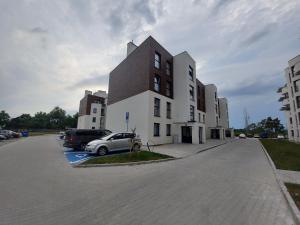 un bâtiment avec une voiture garée sur un parking dans l'établissement kawalerka na Piastowskim, à Carolinensiel
