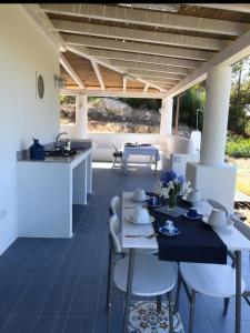 un patio con tavolo e sedie e una cucina di Le Dimore della Villa dei Sogni a Vulcano