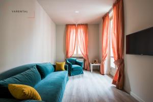 sala de estar con sofá azul y TV en Carlina Palace by Varental en Turín