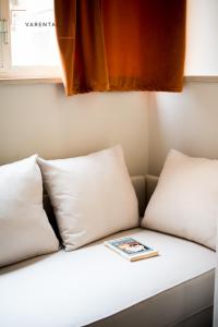 a book sitting on top of a couch with pillows at Carlina Palace by Varental in Turin