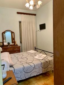a bedroom with a bed and a dresser and a mirror at La Casa di Gabry in Valledolmo