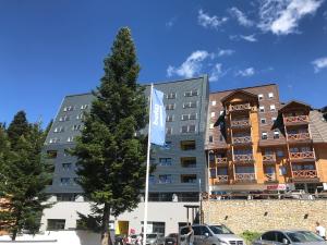 a building with a blue flag in front of it at Olimpijska kuca Jahorina - Apartman A708 in Jahorina