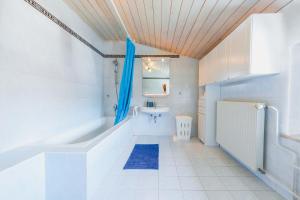 a white bathroom with a tub and a sink at DREAMLAND BLED Apartments in Bled