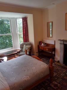 A bed or beds in a room at Bryncoed Guest House 