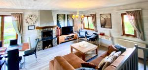 a living room with a couch and a fireplace at Chalet Ardenne Routy in Rochehaut