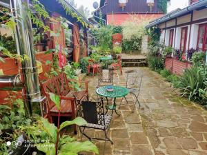 un patio con mesa y sillas en un jardín en Penzion Nostalgie 1876 en Chřibská