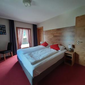 a bedroom with a large bed with a wooden headboard at Pension Zeegershof in Heiterwang