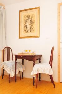 Saint-Martin-de-Caralpにあるle relais des feesのダイニングテーブル(椅子2脚付)が備わります。壁に絵が描かれています。