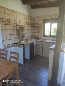 a kitchen with a sink and a table and a window at La Vega del Prado in Tarifa +7 photos