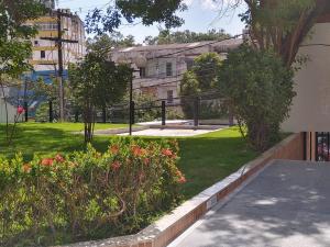 um parque com flores e árvores e um edifício em Barra Summer flat em Salvador