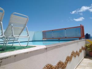 a patio with a chair and a swimming pool at Barra Summer flat in Salvador