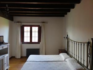 1 dormitorio con 2 camas y ventana en Posada El Jardin de Angela, en Santander