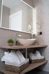 ein Badezimmer mit Waschbecken, Spiegel und Handtüchern in der Unterkunft Villa Ohana in Roquetas de Mar