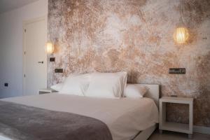 ein Schlafzimmer mit einem weißen Bett und einer Wand in der Unterkunft Villa Ohana in Roquetas de Mar + 37 Fotos