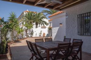 ein Holztisch und Stühle auf einer Terrasse in der Unterkunft Villa Ohana in Roquetas de Mar