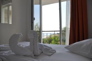 a bedroom with white towels on a bed with a window at Hotel Cosmos in Eforie Sud