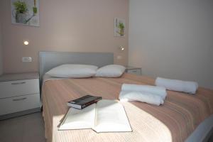 a bedroom with a bed with a book on it at Apartments Medvidovic in Baška Voda
