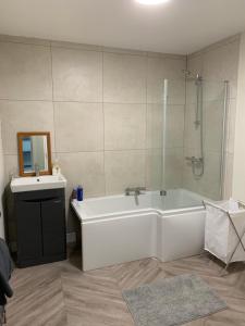 Plaza suite 61 B في بانغور: حمام مع حوض أبيض ومغسلة