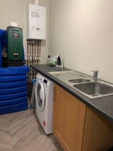 a kitchen with a sink and a washing machine at Plaza suite 61 B in Bangor