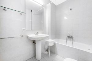 a white bathroom with a sink and a bath tub at Abelletes Apartments in Pas de la Casa