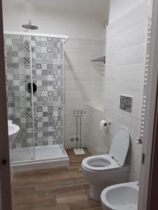 uma casa de banho branca com um WC e um chuveiro em andri.trastevere em Roma