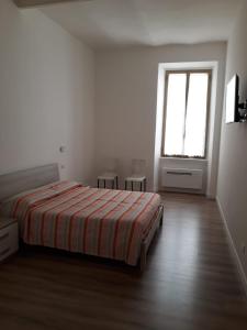 um quarto branco com uma cama e uma janela em andri.trastevere em Roma