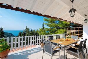 a table and chairs on a patio with a white fence at Villa Paparouna in Magaziá