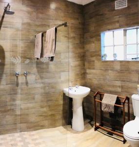 y baño con lavabo, aseo y ducha. en Berghaven Cottages, en Winterton