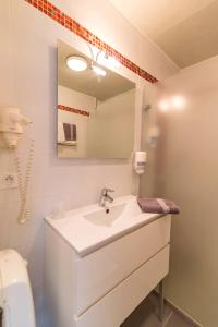 Baño blanco con lavabo y espejo en L'Hippocampe, en Plouharnel