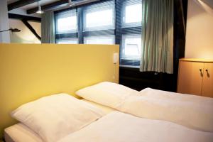 ein Bett mit weißer Bettwäsche und Kissen in einem Schlafzimmer in der Unterkunft Suite „Niedersachsen“ - wunderschönes Apartment in Fachwerkhaus in Hannover