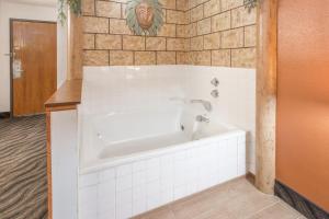 a bath tub in a bathroom with white tiles at Super 8 by Wyndham Dixon in Dixon