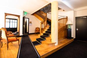 a living room with a staircase with a mirror at Hôtel Restaurant De La Poste & Du Lion D'or in Vézelay