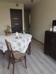 uma mesa de jantar com uma toalha de mesa branca e cadeiras em Kaimo apartamentai! em Budraičiai