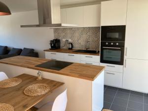 una cucina con armadi bianchi e ripiano in legno di Apartmán MAAY a Hlohovec