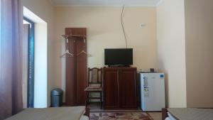 a small room with a tv and a refrigerator at Садиба у Яноша in Vynohradiv