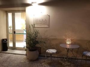 une table et des chaises dans une pièce avec une plante en pot dans l'établissement Aqua Boutique Hotel, à Castiglione della Pescaia